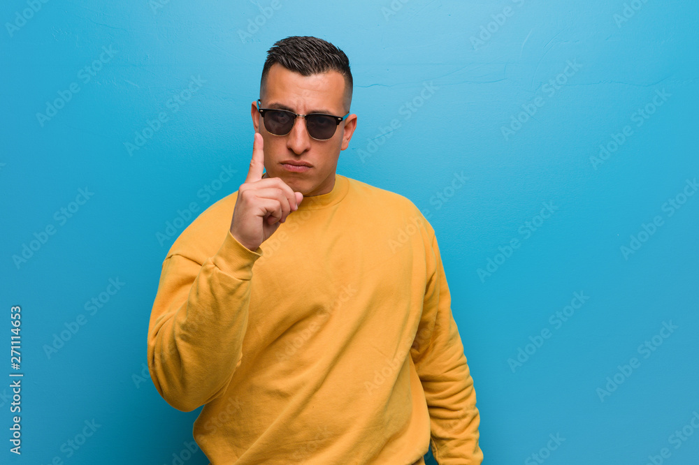 Young colombian man showing number one Young colombian man showing number one
