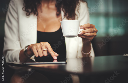 Woman having coffee and using tablet