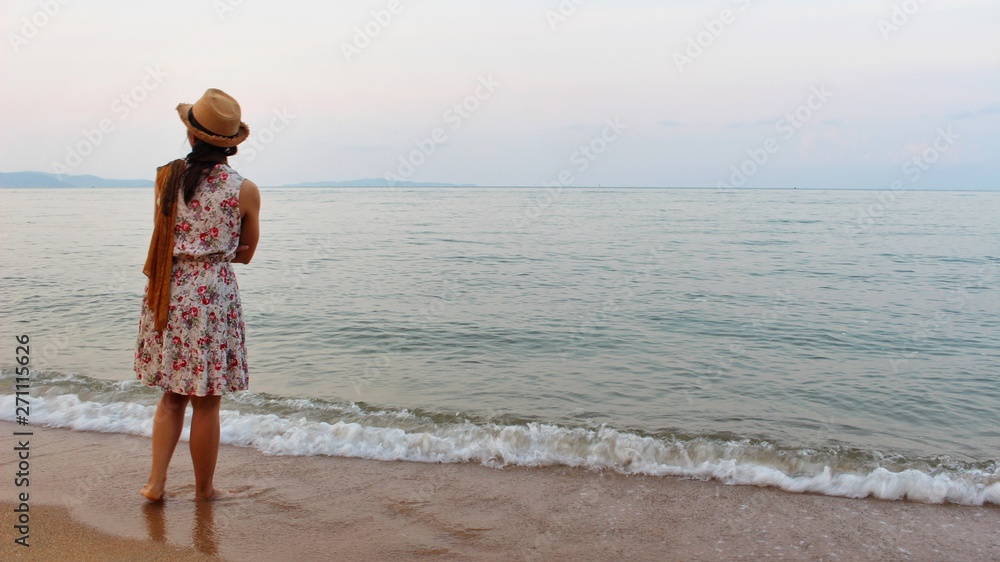  The girl standing on the beach by the sea in the evening took a blurred photo