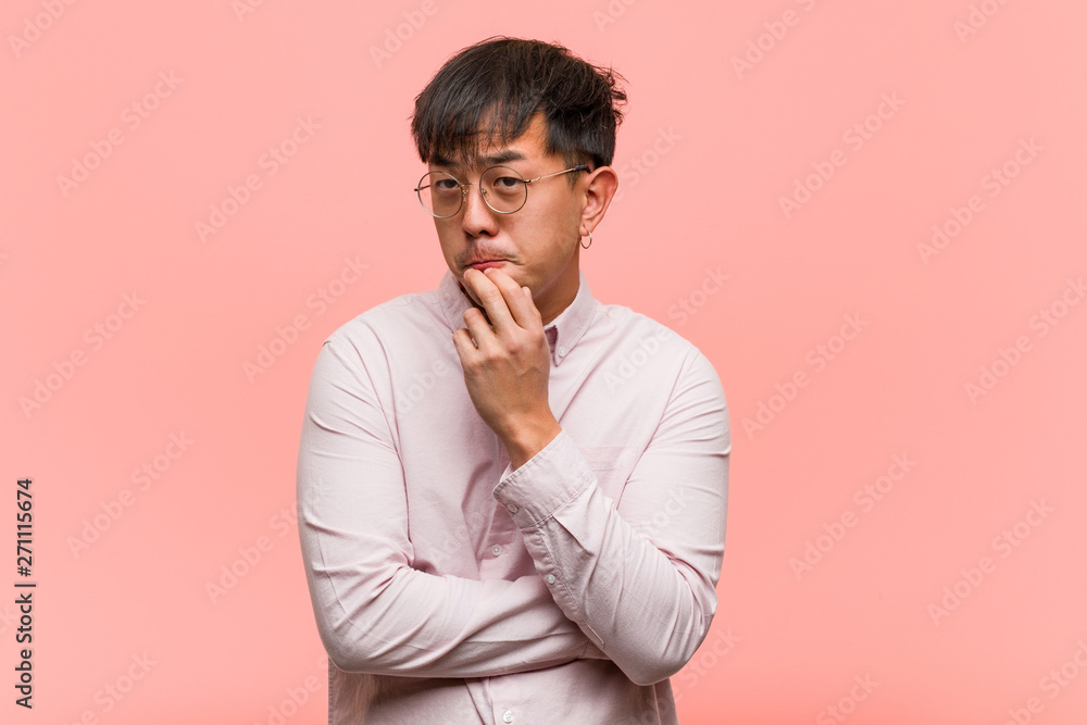 Young chinese man thinking about an idea Young chinese man thinking about an idea