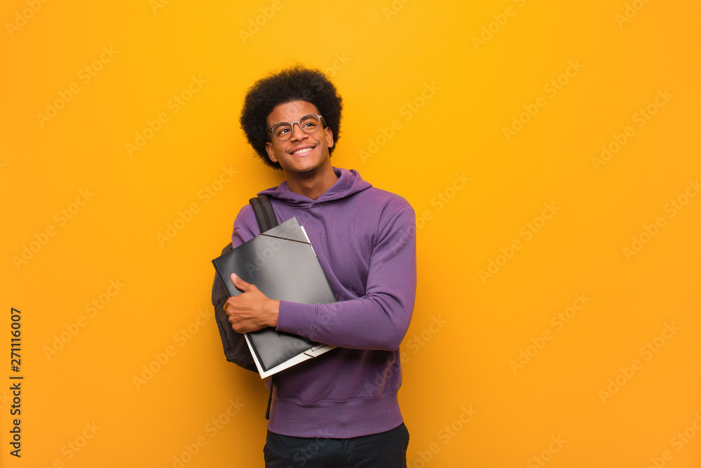 Young african american student man smiling confident and crossing arms, looking up - obrazy, fototapety, plakaty 