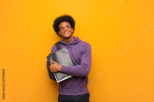 Young african american student man smiling confident and crossing arms, looking up