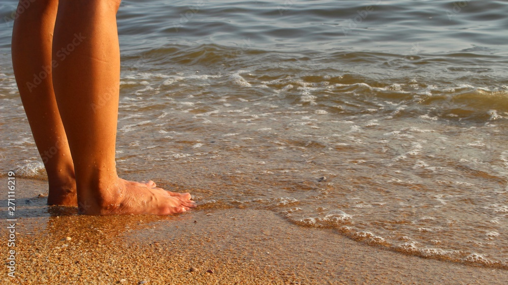 The girl standing on the beach by the sea in the evening The girl standing on the beach by the sea in the evening