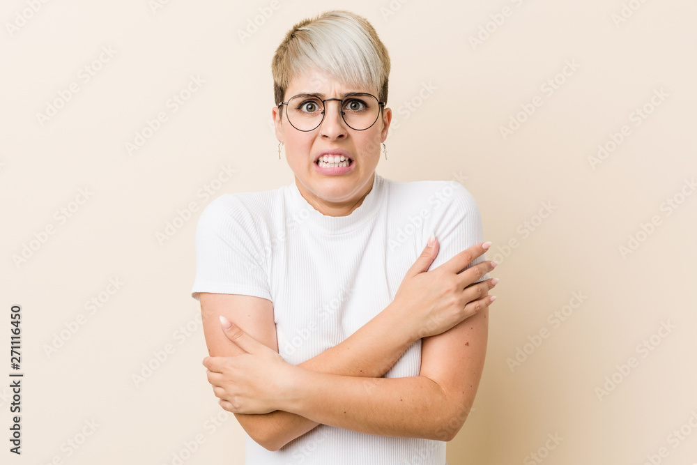 Young authentic natural woman wearing a white shirt going cold due to low temperature or a sickness. Young authentic natural woman wearing a white shirt going cold due to low temperature or a sickness.