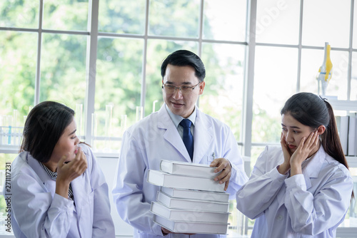 Senior asian scientist has assigning new job to students in laboratory.