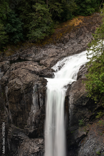 The top of the majestic Elk Falls as it crashes over the top on the Campbell River, Vancouver Island, Canada, on a long exposure to create motion blur to the falling water nobody in the iamge