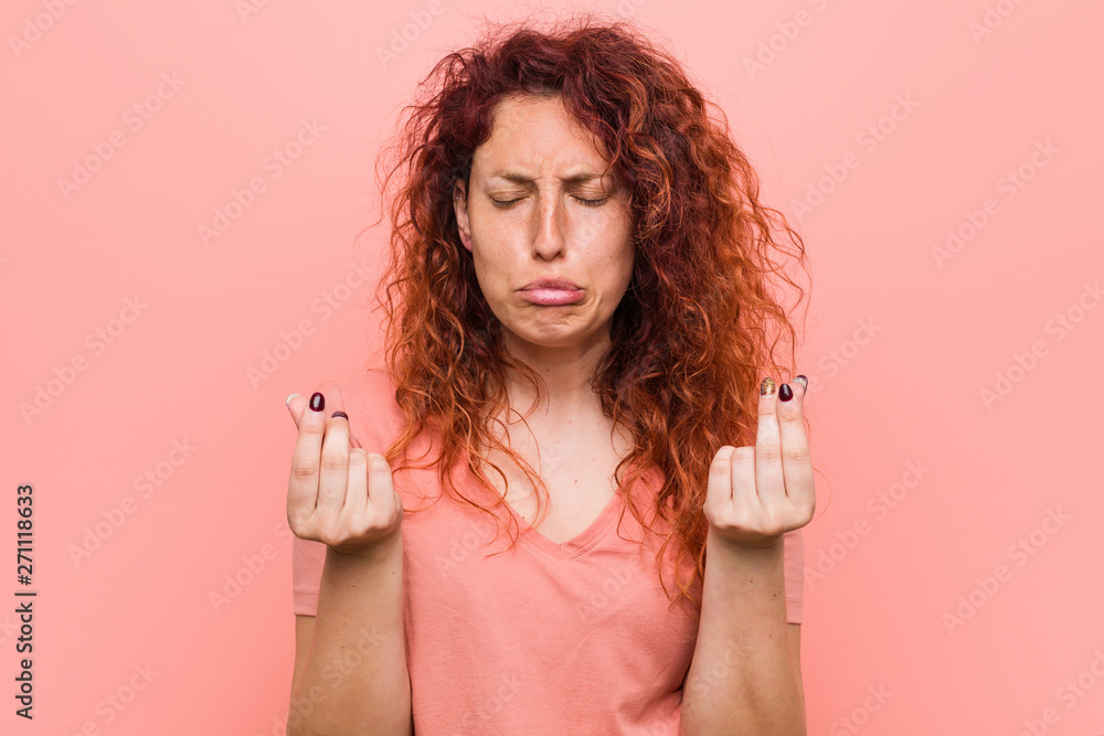 Young natural and authentic redhead woman showing that she has no money.