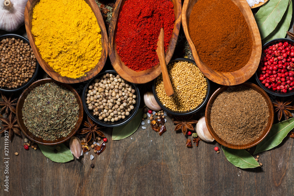 assortment of spices on a wooden background, top view