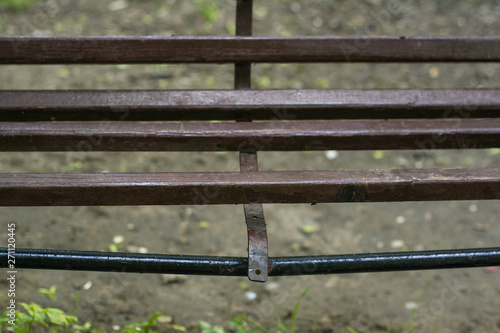 Broken wooden bench with metal frame in the park