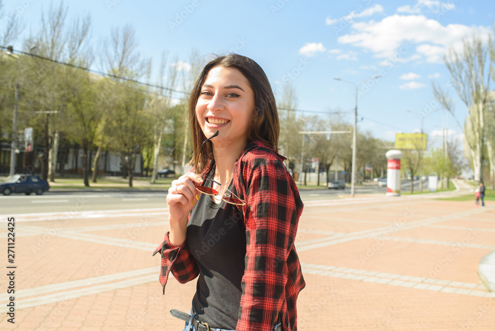 Happy girl walks down the street in spring around the city