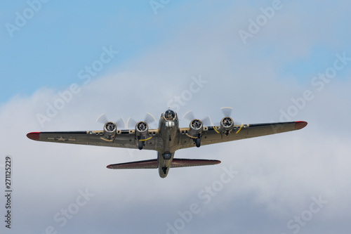 фотографія WWII bomber (B-17 Flying Fortress) raising against clouds
