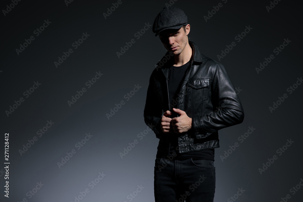 Serious looking man adjusting his black leather jacket Serious looking man adjusting his black leather jacket