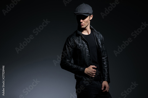 Dramatic looking guy pulling his black leather jacket