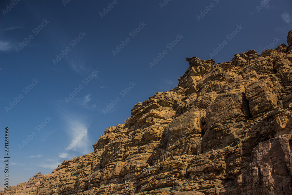 Naklejka premium desert sand stone rocky mountains photography foreshortening from below on blue sky background