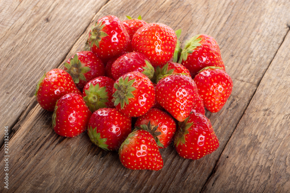 heap of strawberries on wooden background. top view