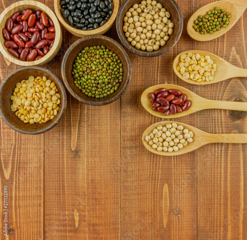 Flat lay,top view assorted beans including red bean,soybeans,black beans,mung beans on brown,beige wooden background with copy space 