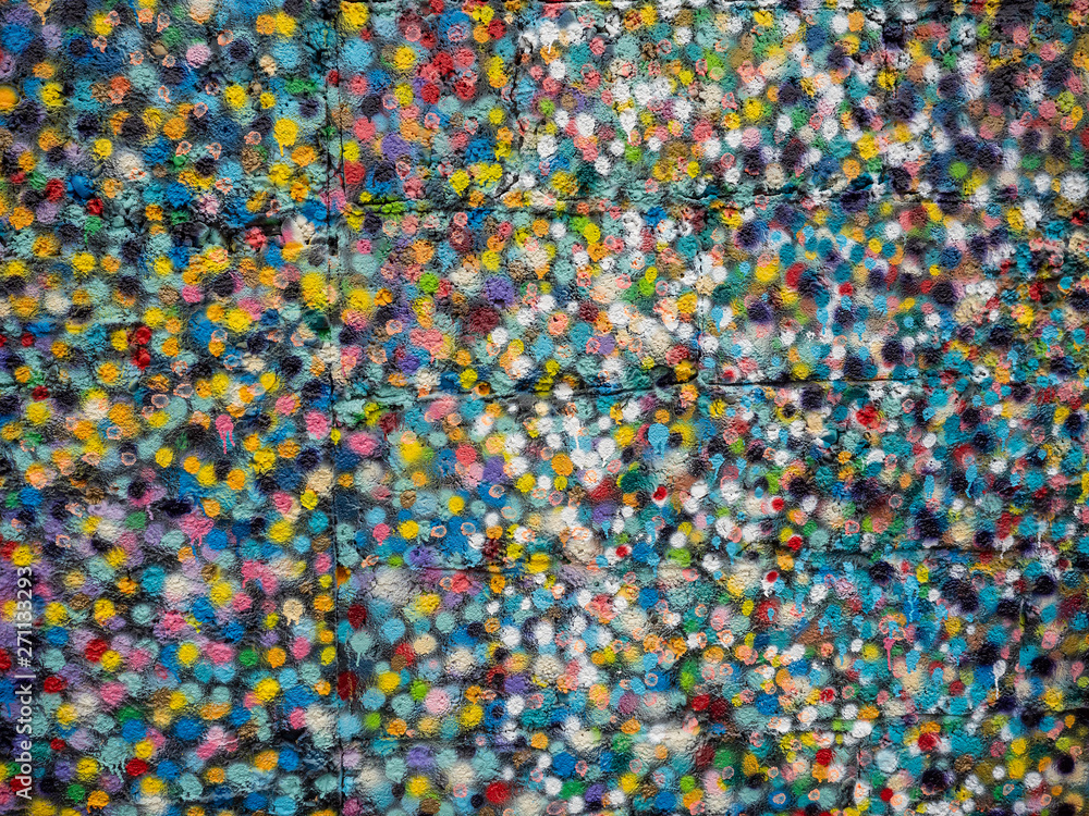 Multicolored abstract background on a stone surface. Spray dots. Red, blue, yellow.