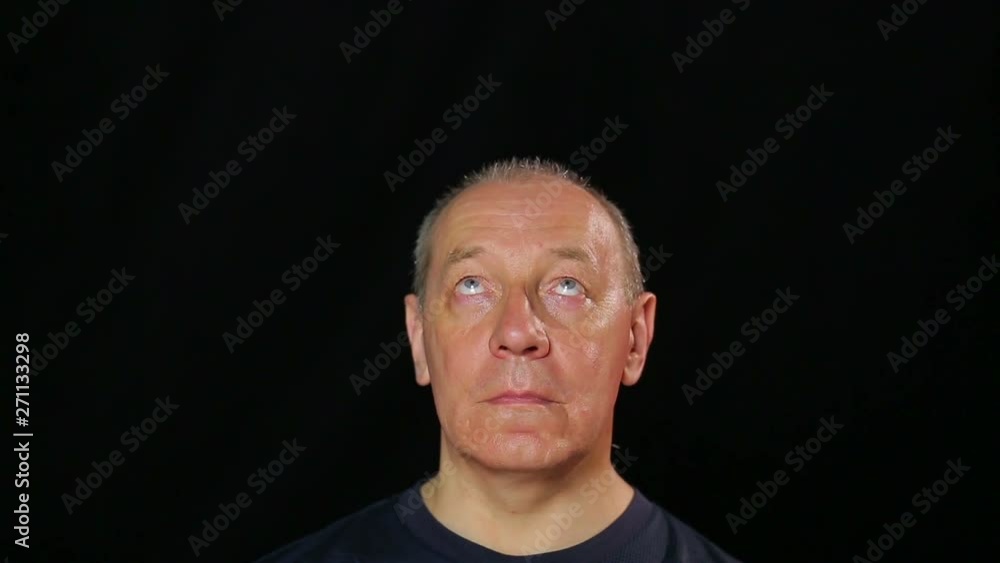 A man does exercises for the eyes by raising and lowering his gaze A man does exercises for the eyes by raising and lowering his gaze