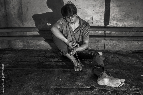 Slika na platnu young man sitting in the basement in chains