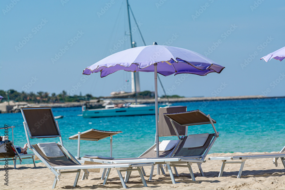 Service on beach, colorful sun bed and parasol for rent on beautiful white sandy beach with crystal clear blue sea water Service on beach, colorful sun bed and parasol for rent on beautiful white sandy beach with crystal clear blue sea water