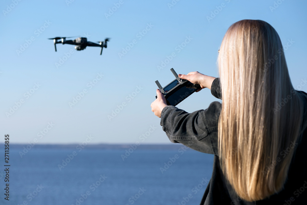 Young girl controls the drone. Drone flight