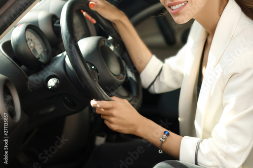 Beautiful girl sitting behind wheel inside car