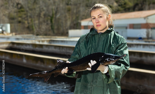 Female owner of sturgeon farm showing fish photo