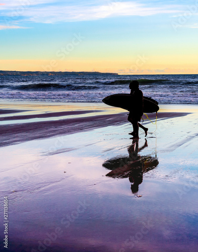 Couple with surfboards at sunset
