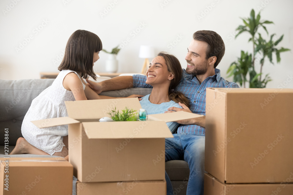 Happy parents have fun with child relaxing on moving day Happy parents have fun with child relaxing on moving day