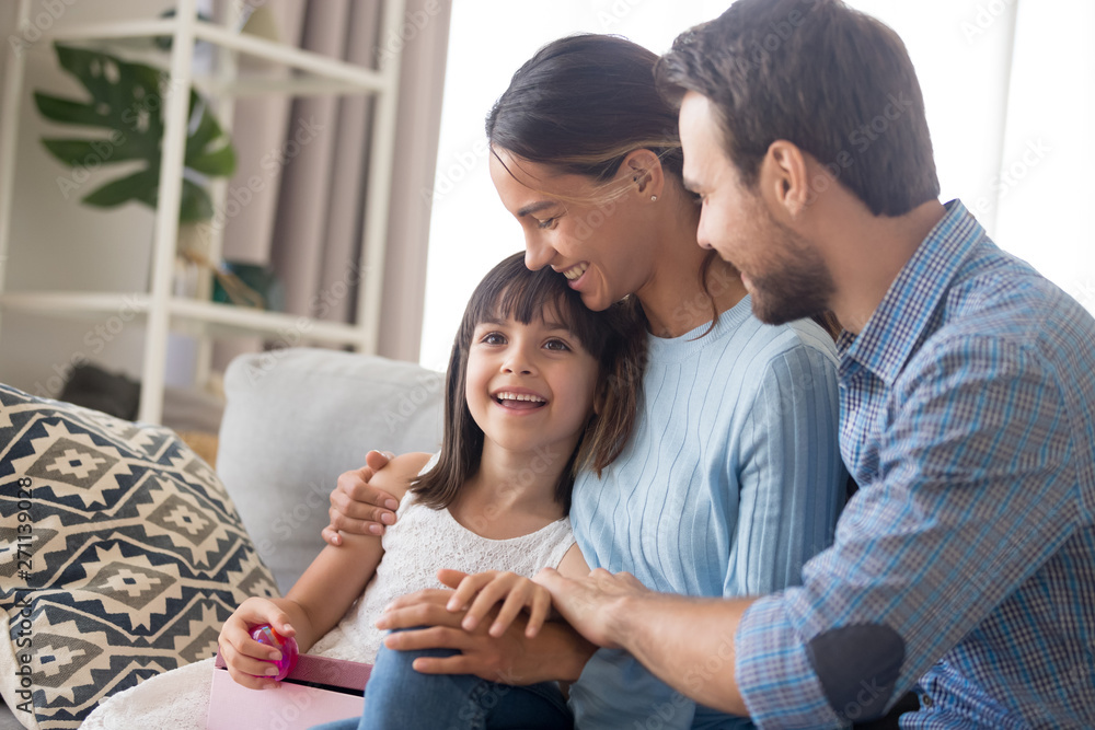 Happy family with kid cuddle on couch congratulating with birthday Happy family with kid cuddle on couch congratulating with birthday