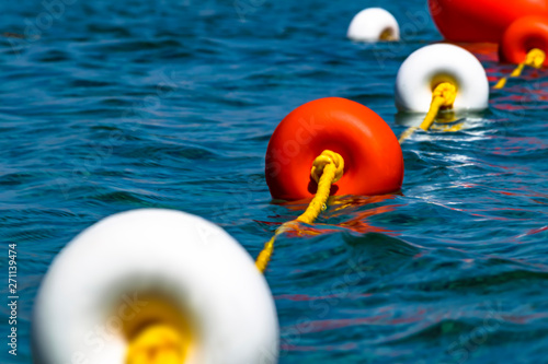 Close-up bright red and white coloers buoys on the surface of the water. Depth marks. Safety on water. photo