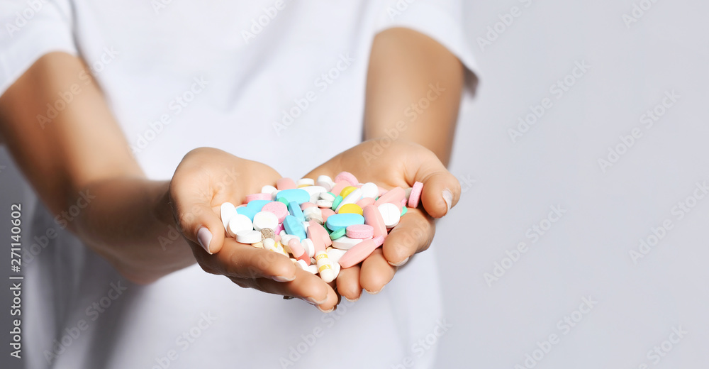 Closeup. Womans heart-shaped hands palms with different color tablet pills diet supplements prescription weight loss drugs Closeup. Womans heart-shaped hands palms with different color tablet pills diet supplements prescription weight loss drugs