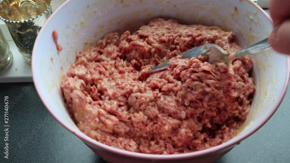 Mixes minced meat with eggs and flour Mixes minced meat with eggs and flour