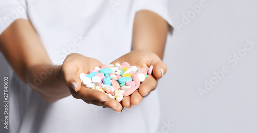 Closeup. Womans heart-shaped hands palms with different color tablet pills diet supplements prescription weight loss drugs