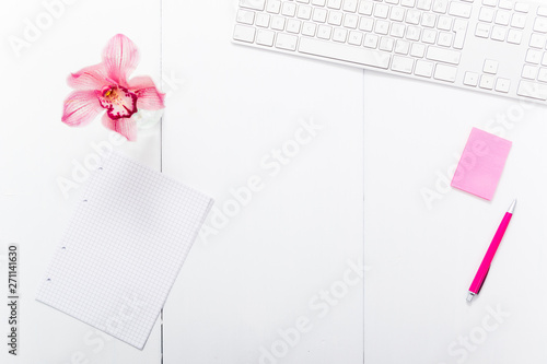 femininity place of work, pink post it, pen, flower on white office desk, copy space, top view