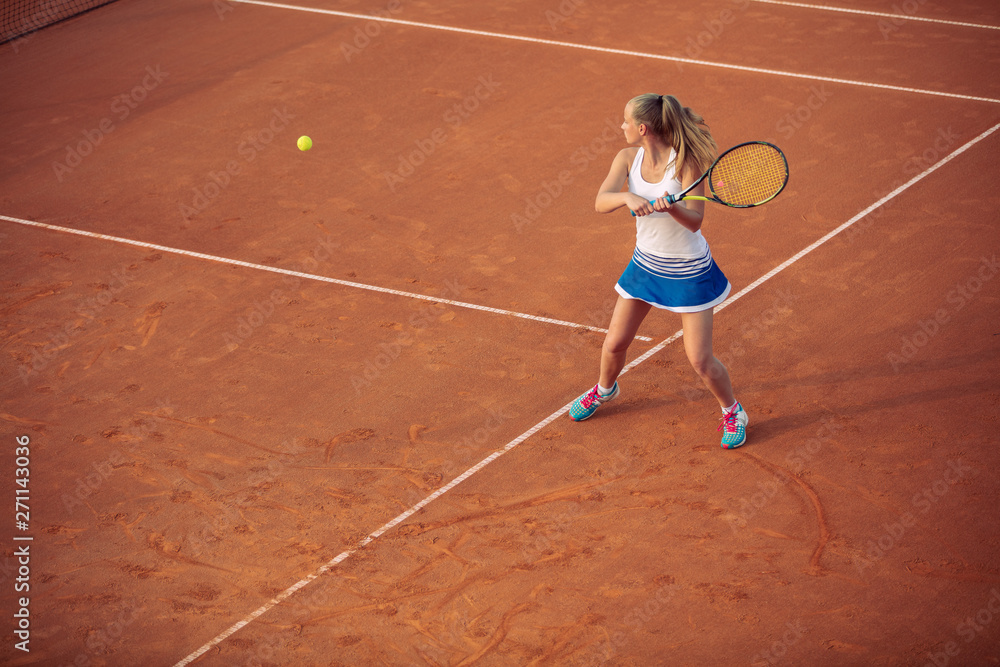 Woman playing tennis on clay court, with sporty outfit and healthy lifestyle Woman playing tennis on clay court, with sporty outfit and healthy lifestyle