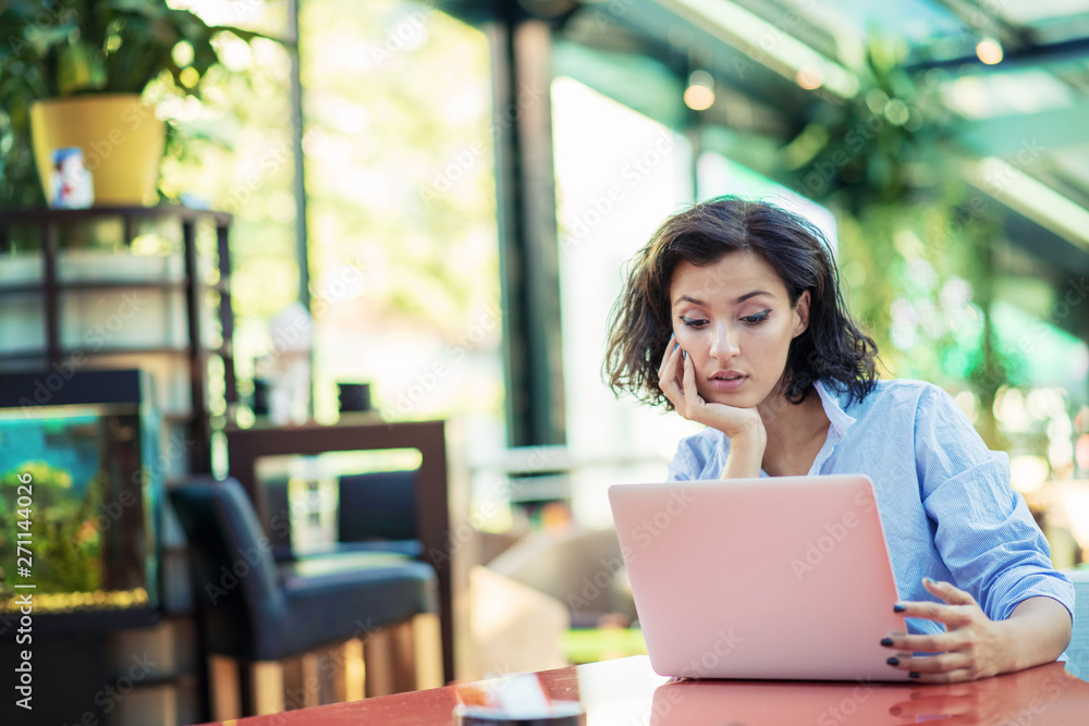 young and beautiful girl with notebook and laptop sitting in a cafe young and beautiful girl with notebook and laptop sitting in a cafe
