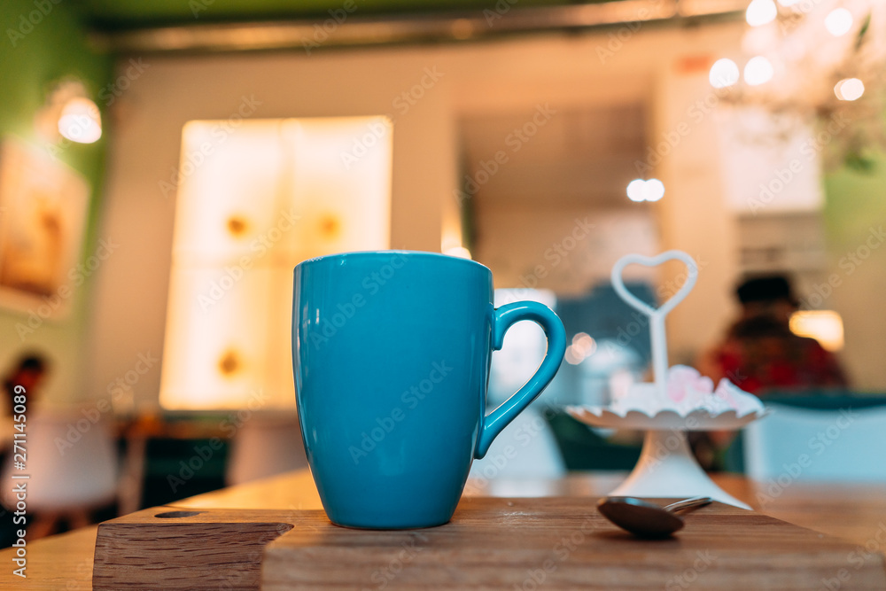 Hot cappuccino coffee in coffee shop on wooden table Hot cappuccino coffee in coffee shop on wooden table