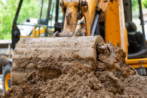 фотографія Excavator bucket pours ground. Repair work plumbing.