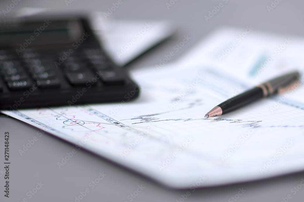 close up.pen, financial chart and calculator on the businessman's Desk close up.pen, financial chart and calculator on the businessman's Desk