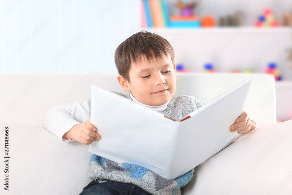preschooler reading a book on the couch in the nursery preschooler reading a book on the couch in the nursery