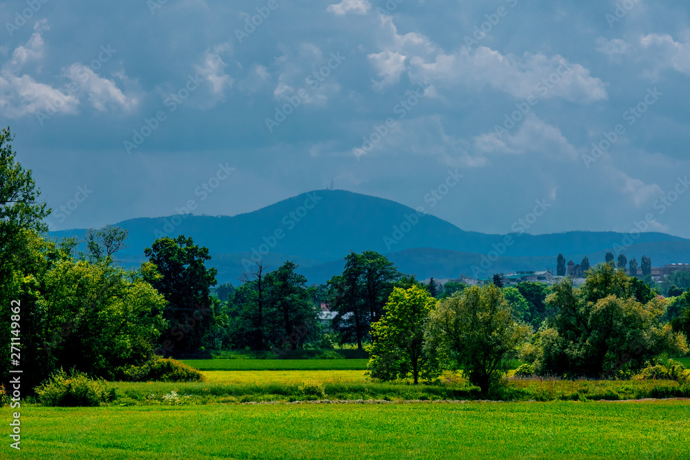 Rural countryside field with mountains and blue sky on background Rural countryside field with mountains and blue sky on background