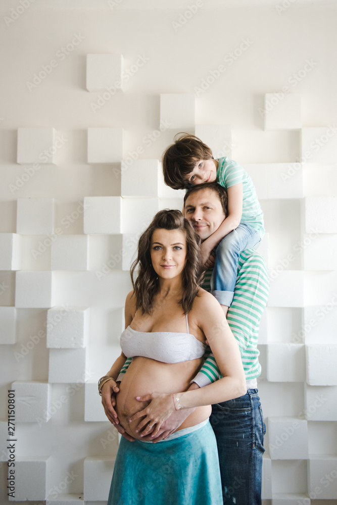 Happy family waiting for a second child. Last months of pregnancy. Pregnant woman with husband and little boy . Second pregnancy, maternity concept. Happy family waiting for a second child. Last months of pregnancy. Pregnant woman with husband and little boy . Second pregnancy, maternity concept.