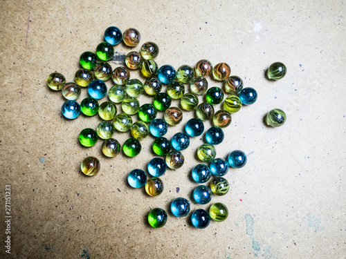 Colored glass balls scattered on a wooden surface