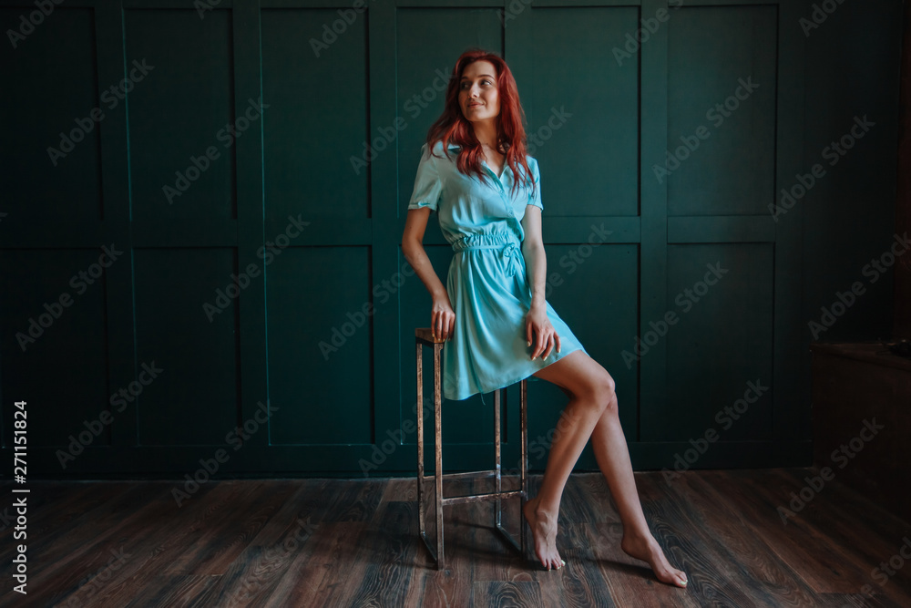 Redhead girl with beautiful legs on dark background