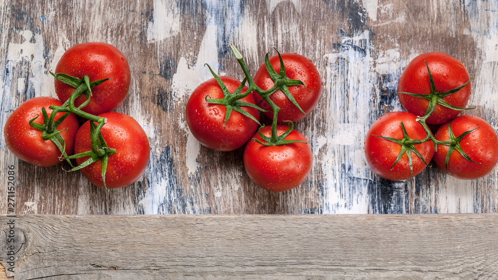 Food banner tomatoes on a branch on a rustic background. Horizontal wood frame Food banner tomatoes on a branch on a rustic background. Horizontal wood frame