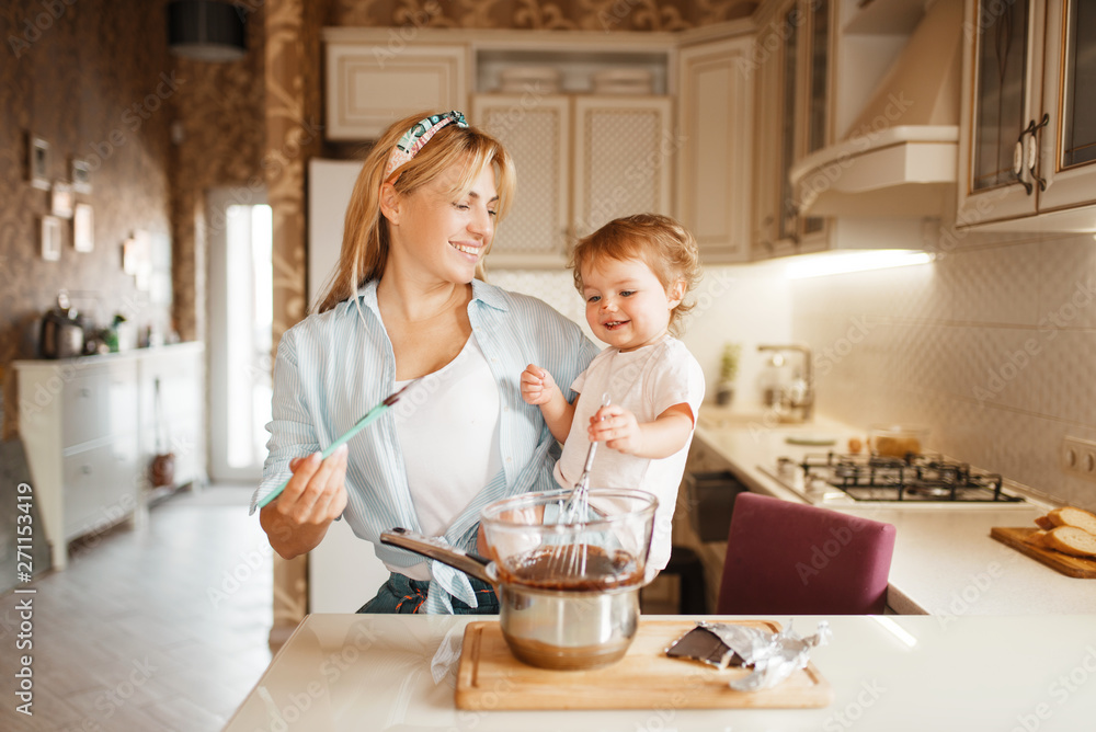 Mother with her daughter mixing melted chocolate Mother with her daughter mixing melted chocolate