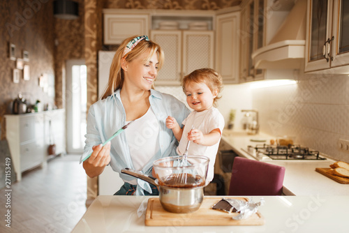 Mother with her daughter mixing melted chocolate