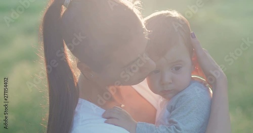 Young mother hugs and caresses her baby. Boy cute snuggles up to woman. in slow motion. Shot on Canon 1DX mark2 4K camera photo