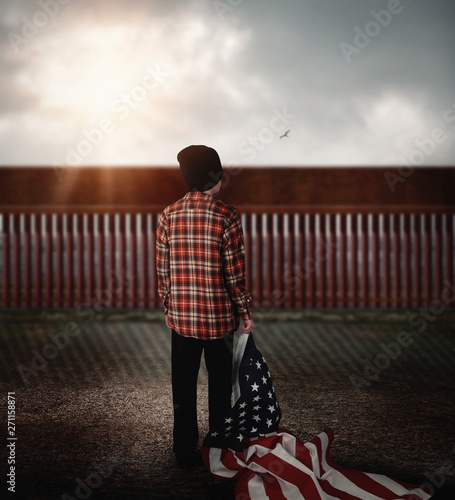 Immigrant Child Looking at Border Wall photo